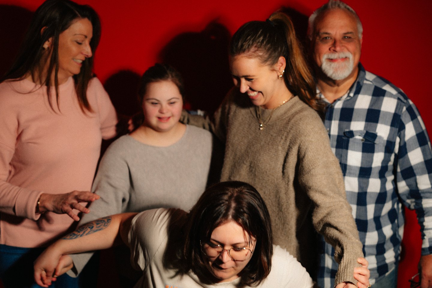 Diverse group of five people smiling and interacting warmly.